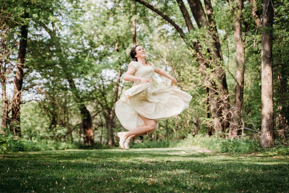 Eine Frau in einem weißen Kleid springt in die Luft