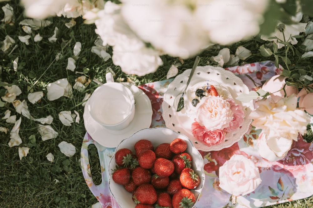 a plate of strawberries and a bowl of strawberries
