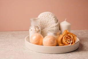 a white bowl filled with bath items next to a candle