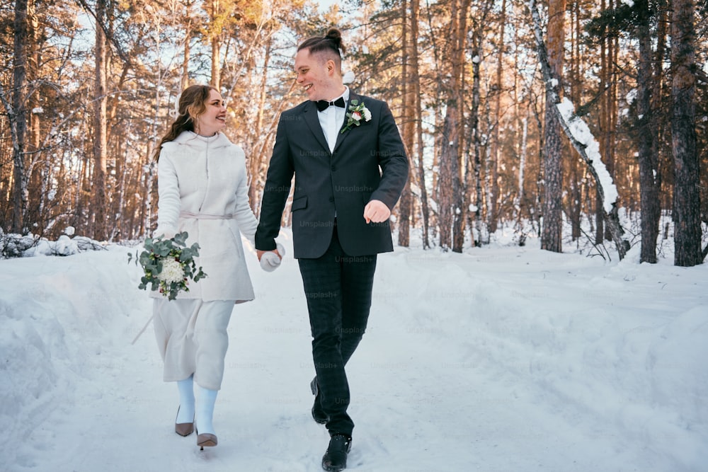 a newly married couple walking through the snow
