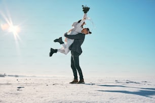 um homem segurando uma mulher nas costas na neve