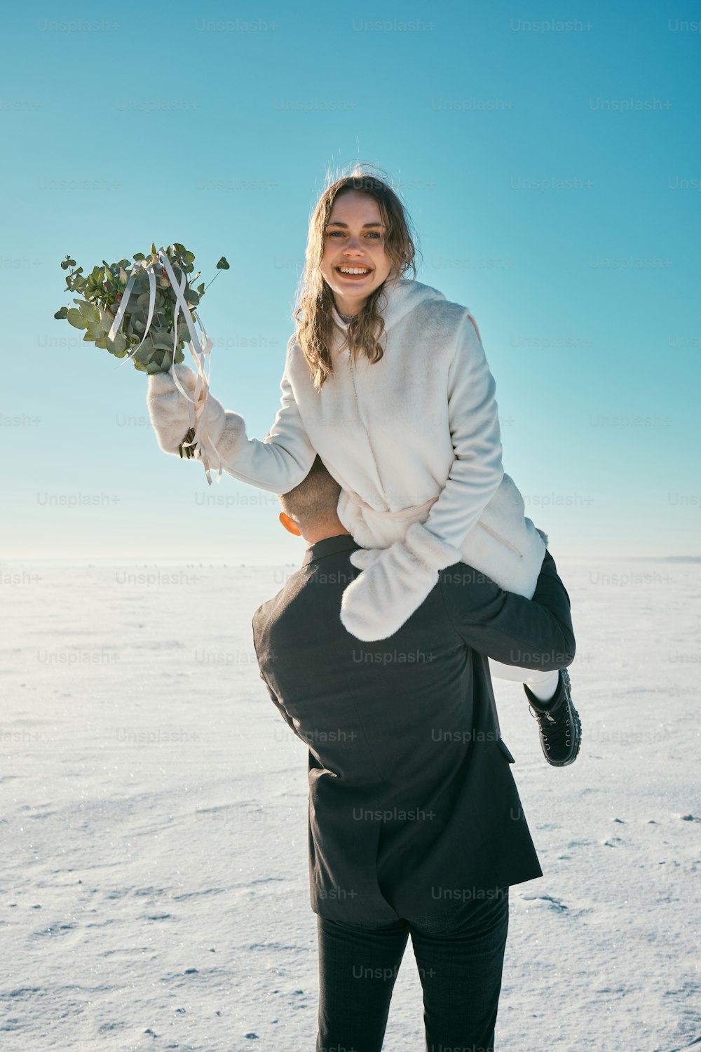 a woman holding a bunch of flowers in the snow
