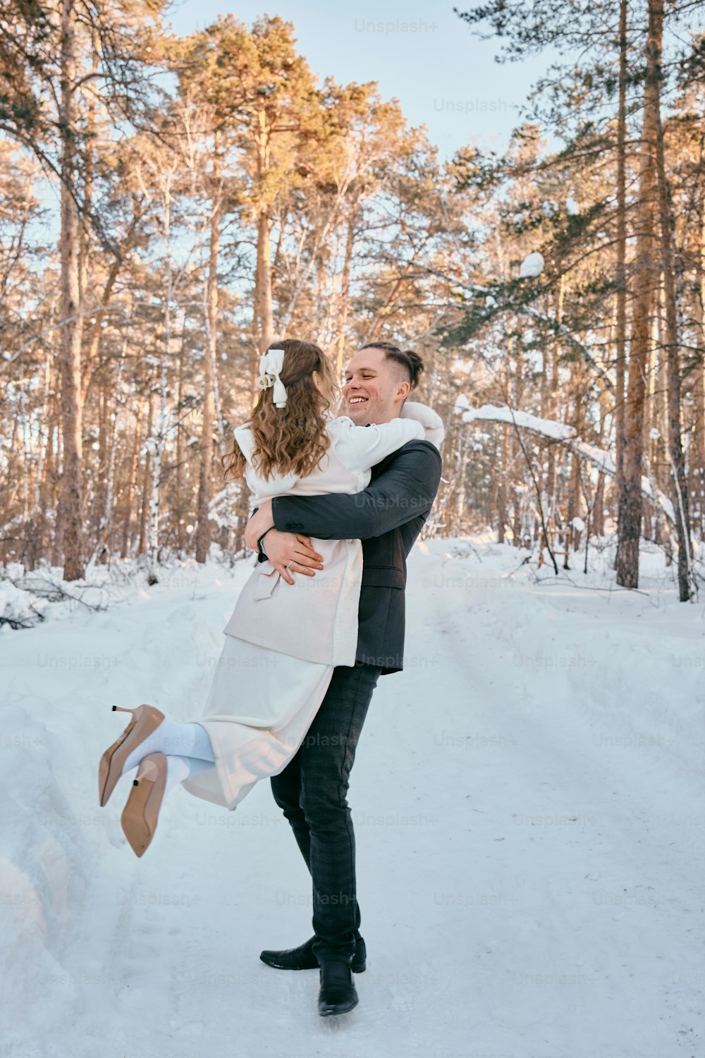 un homme tenant une femme dans la neige