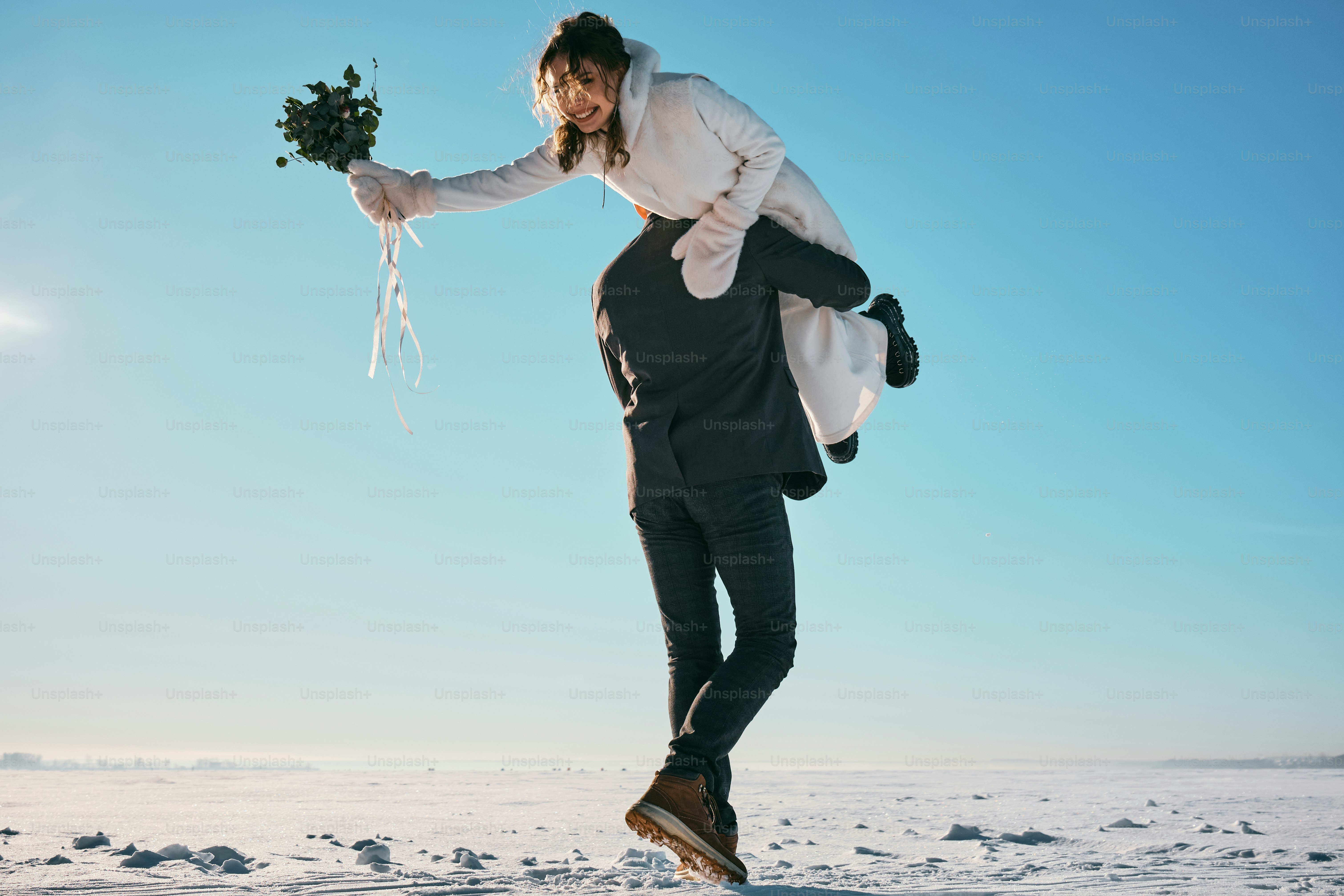 a woman holding a bunch of flowers in the snow