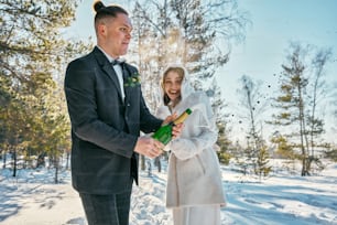 a bride and groom standing in the snow