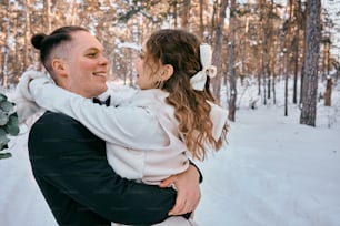 a man holding a little girl in the snow