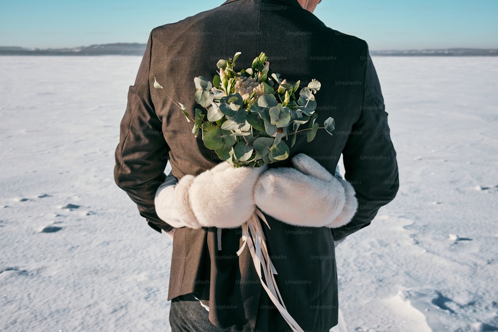 um homem de terno segurando um buquê de flores