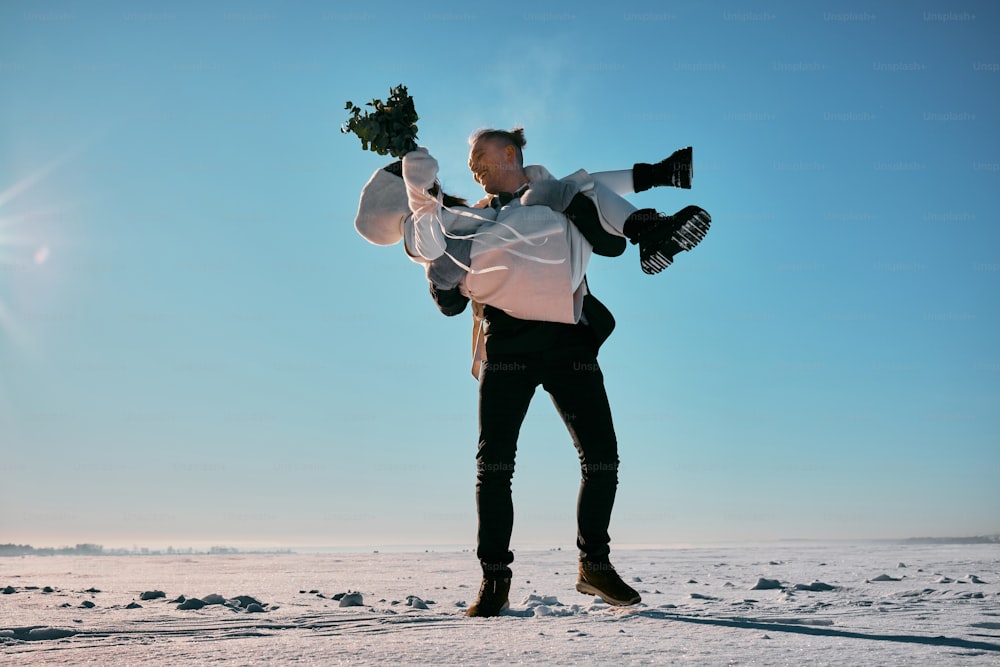 a man holding a bouquet of flowers in the snow