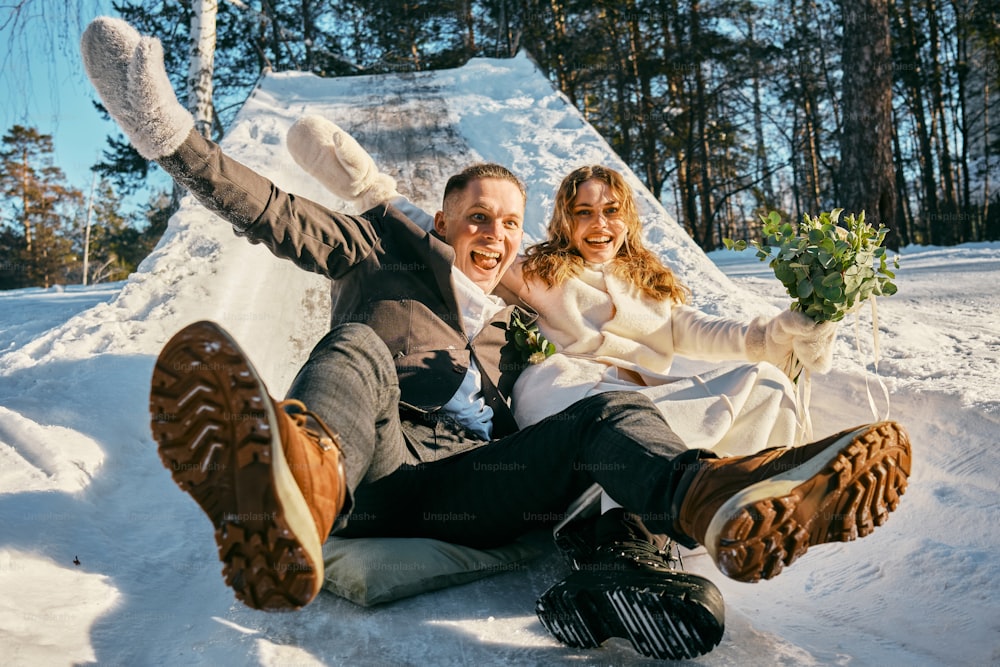 una sposa e uno sposo sono seduti nella neve