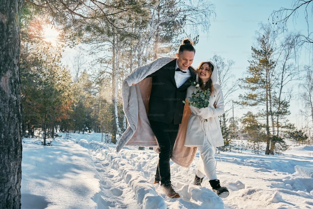 une mariée et un marié marchant dans la neige