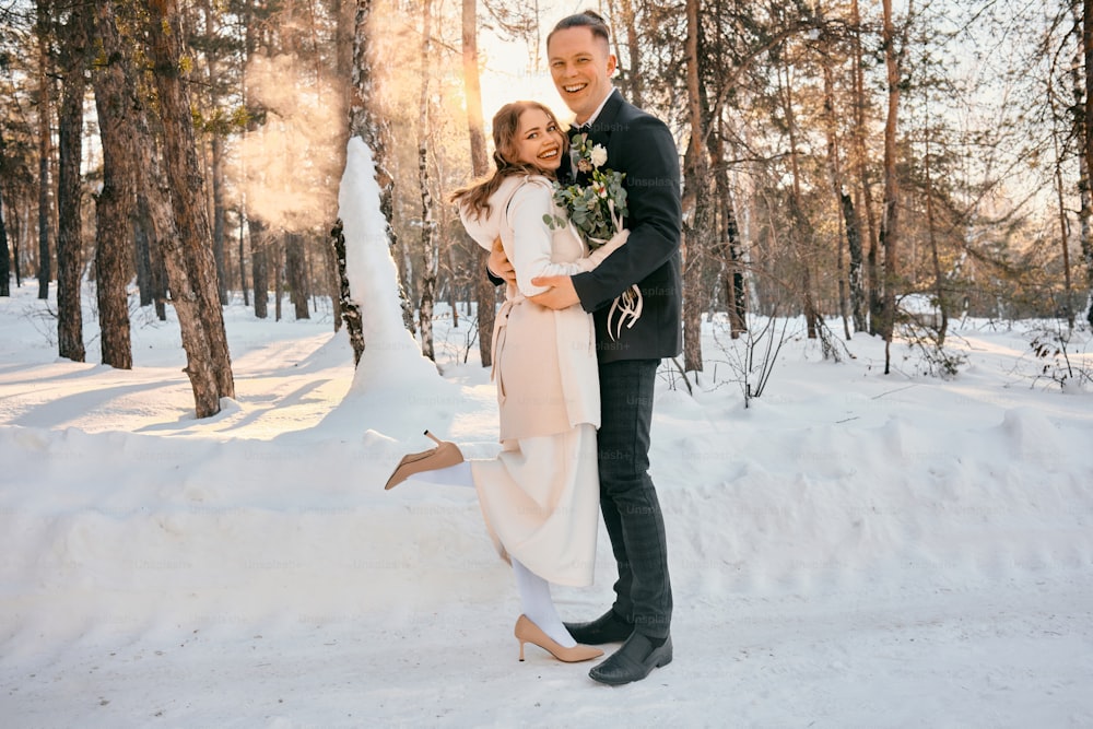 a bride and groom standing in the snow