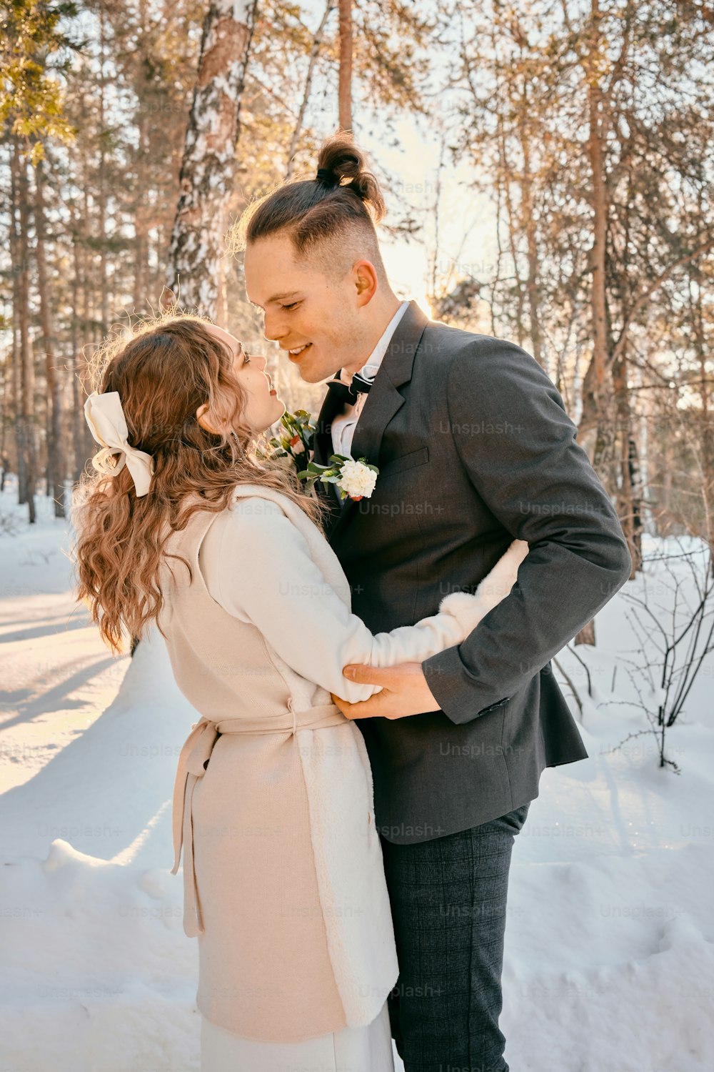 a bride and groom standing in the snow