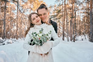 a man holding a woman in the snow