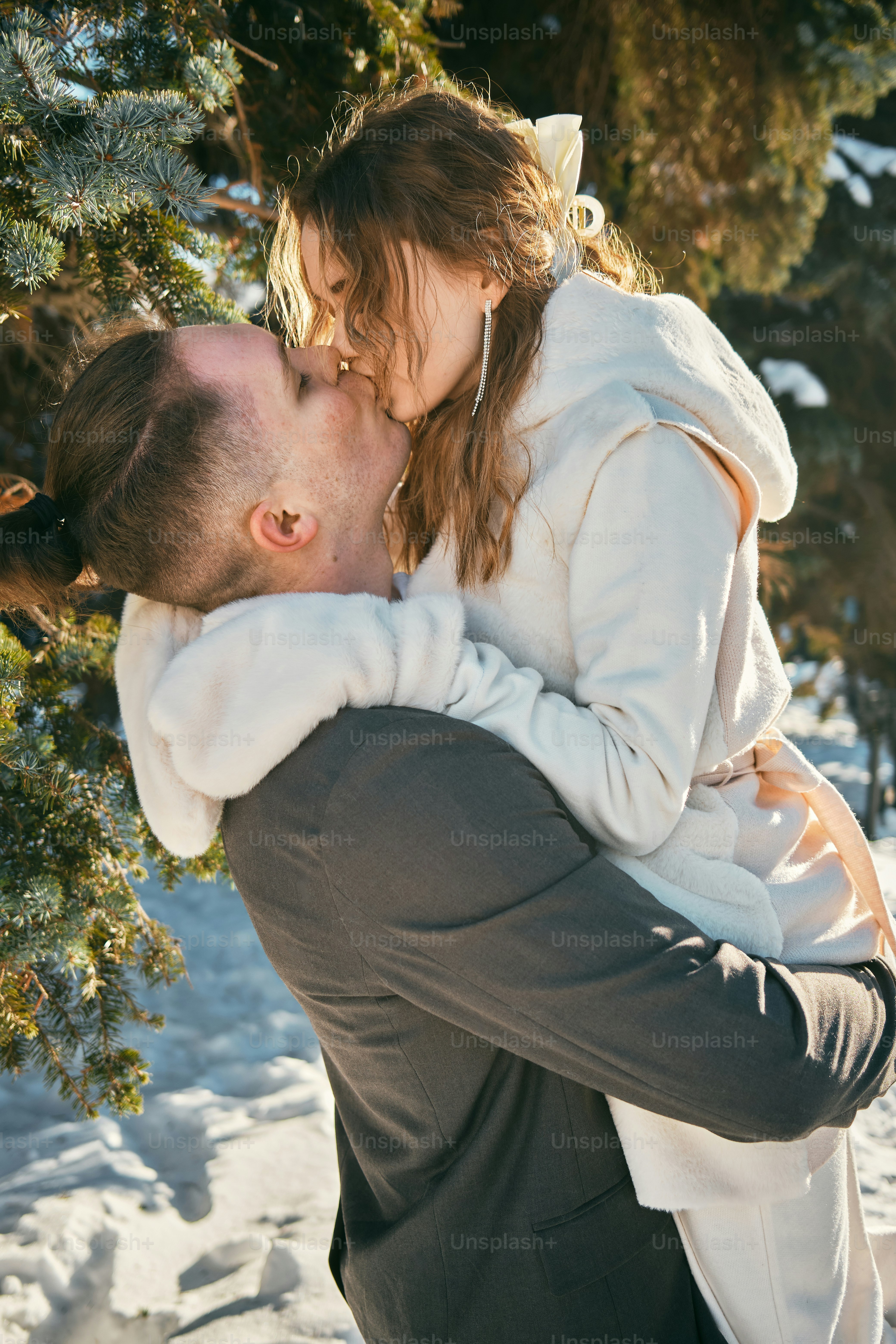 a man and a woman kissing in the snow