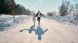 a man and a woman are running in the snow