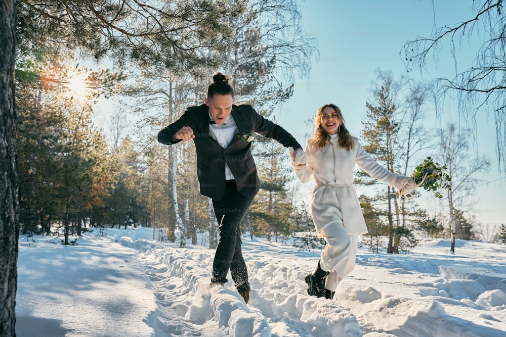 a bride and groom running through the snow