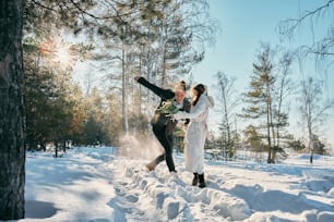 um par de pessoas que estão de pé na neve