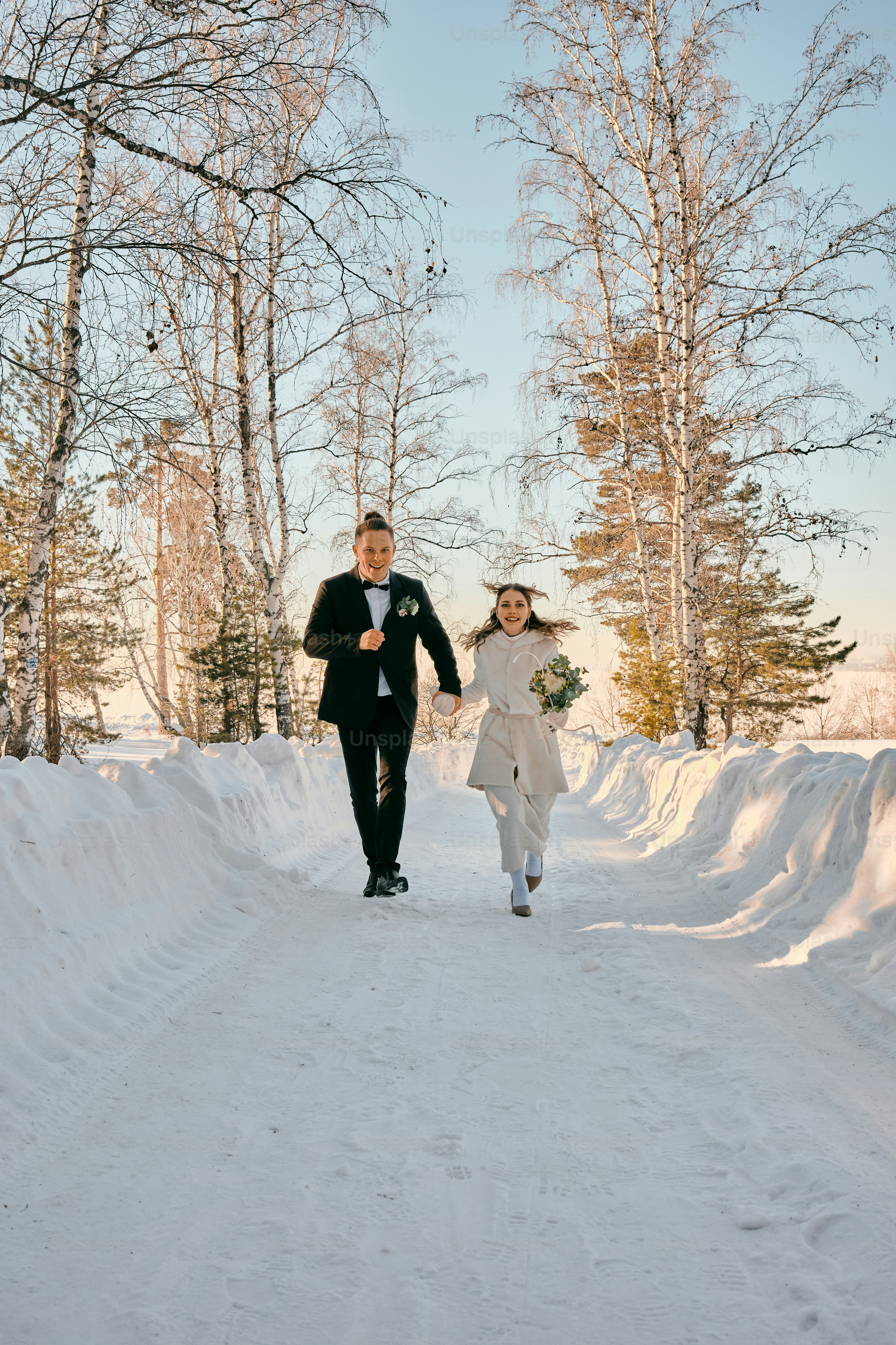 una novia y un novio caminando por la nieve