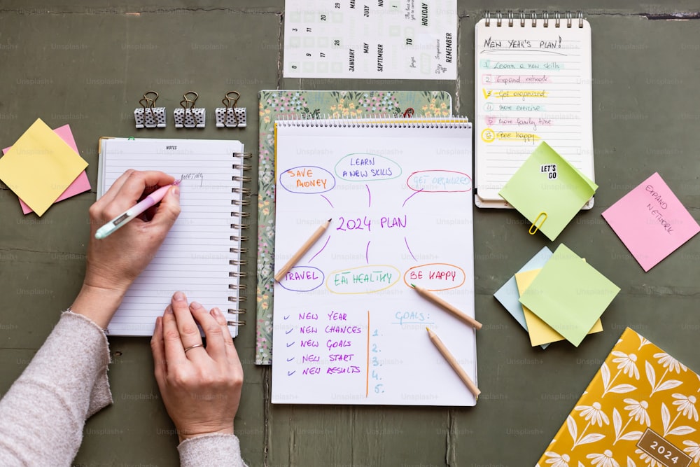 a person is writing on a notepad with sticky notes