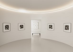 벽에 네 장의 흑백 사진이 걸려 있는 하얀 방