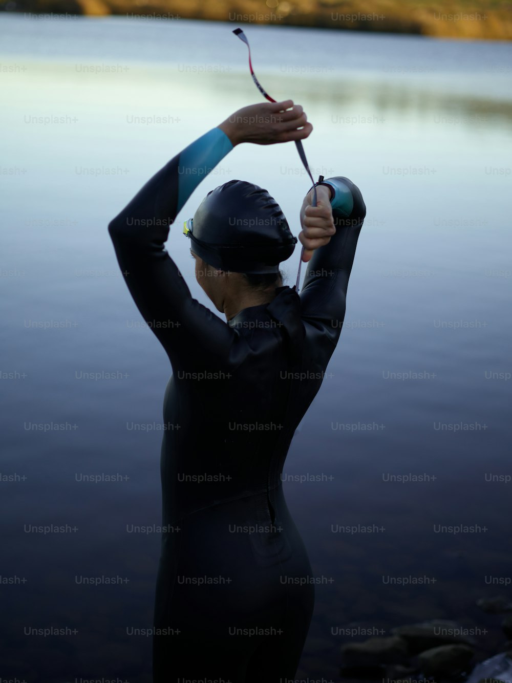 une femme en combinaison de plongée tenant une canne à pêche