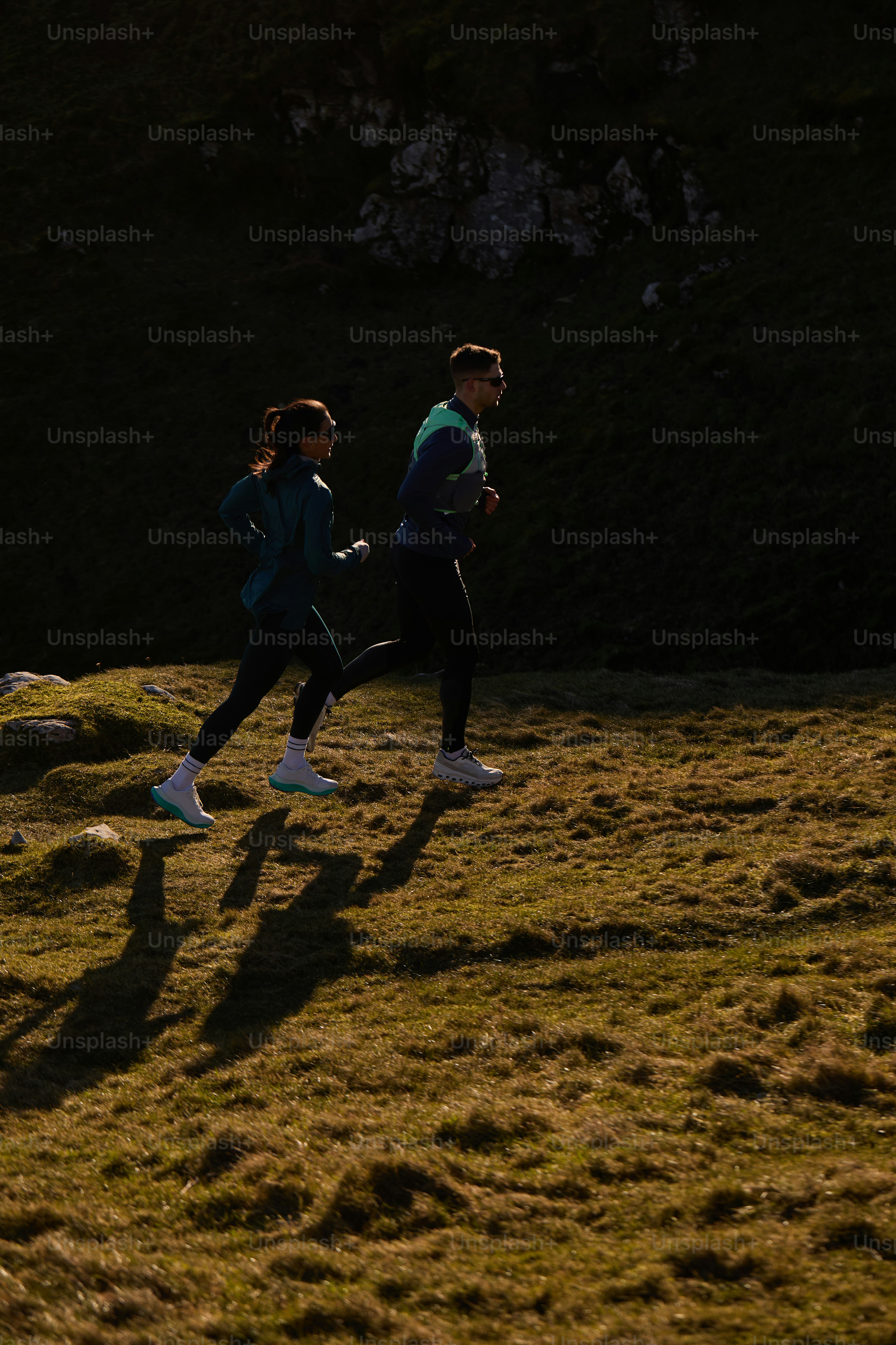 Un par de personas que corren por la hierba