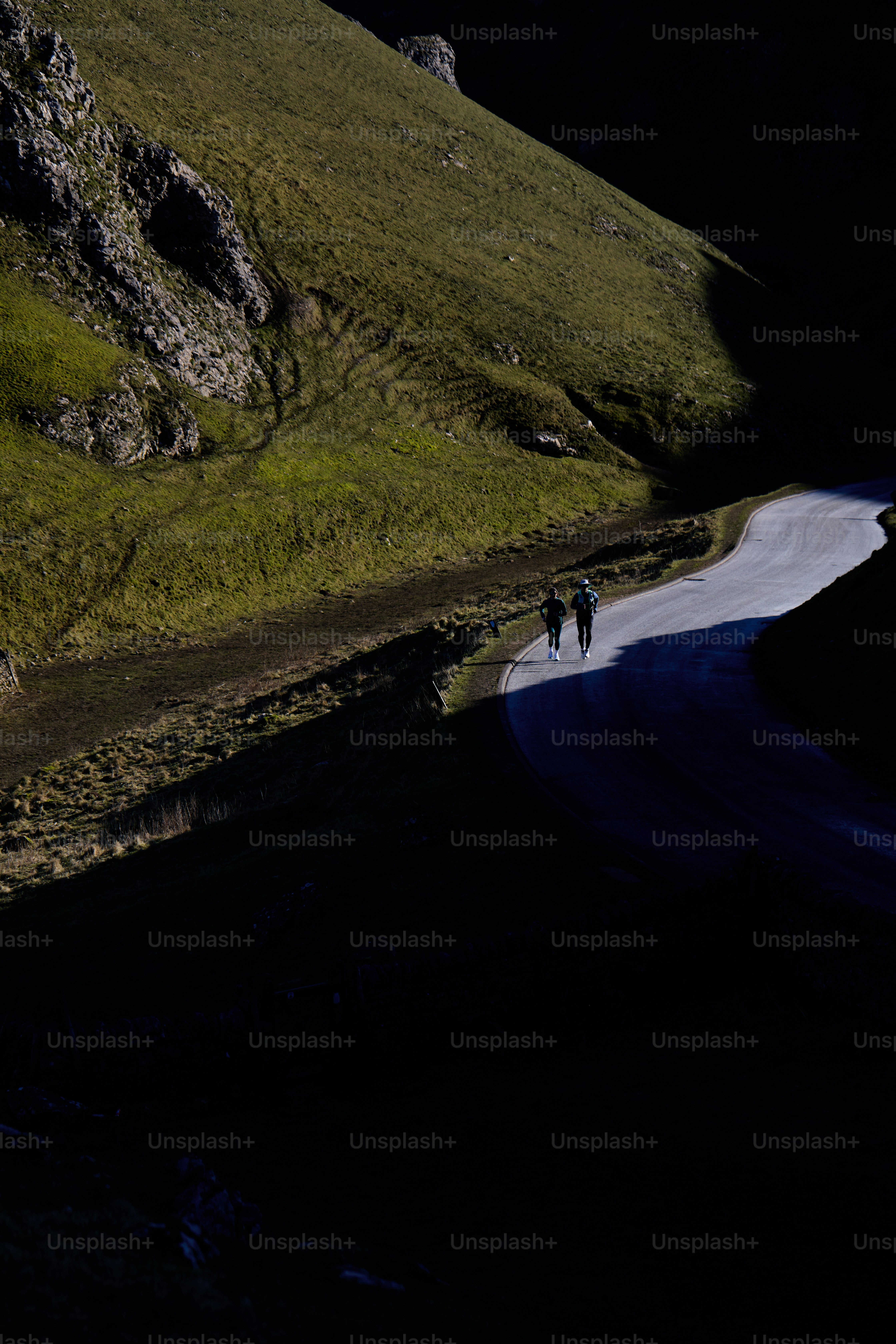 two people walking down a road in the dark