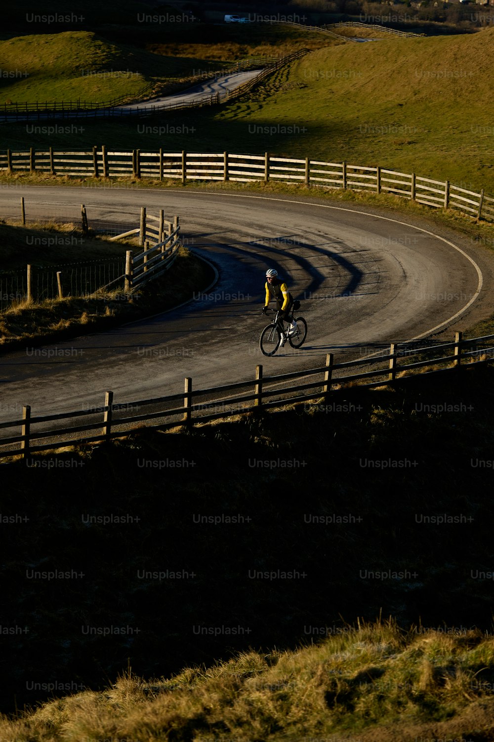 a man riding a bike down a curvy road