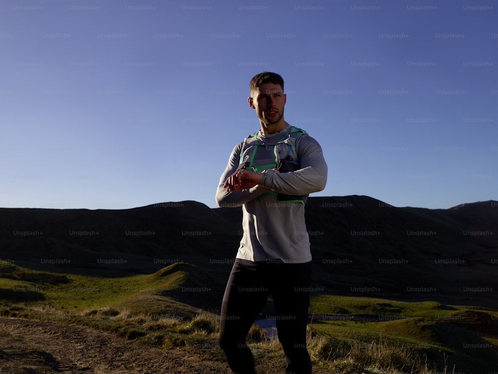 a man standing on top of a lush green hillside