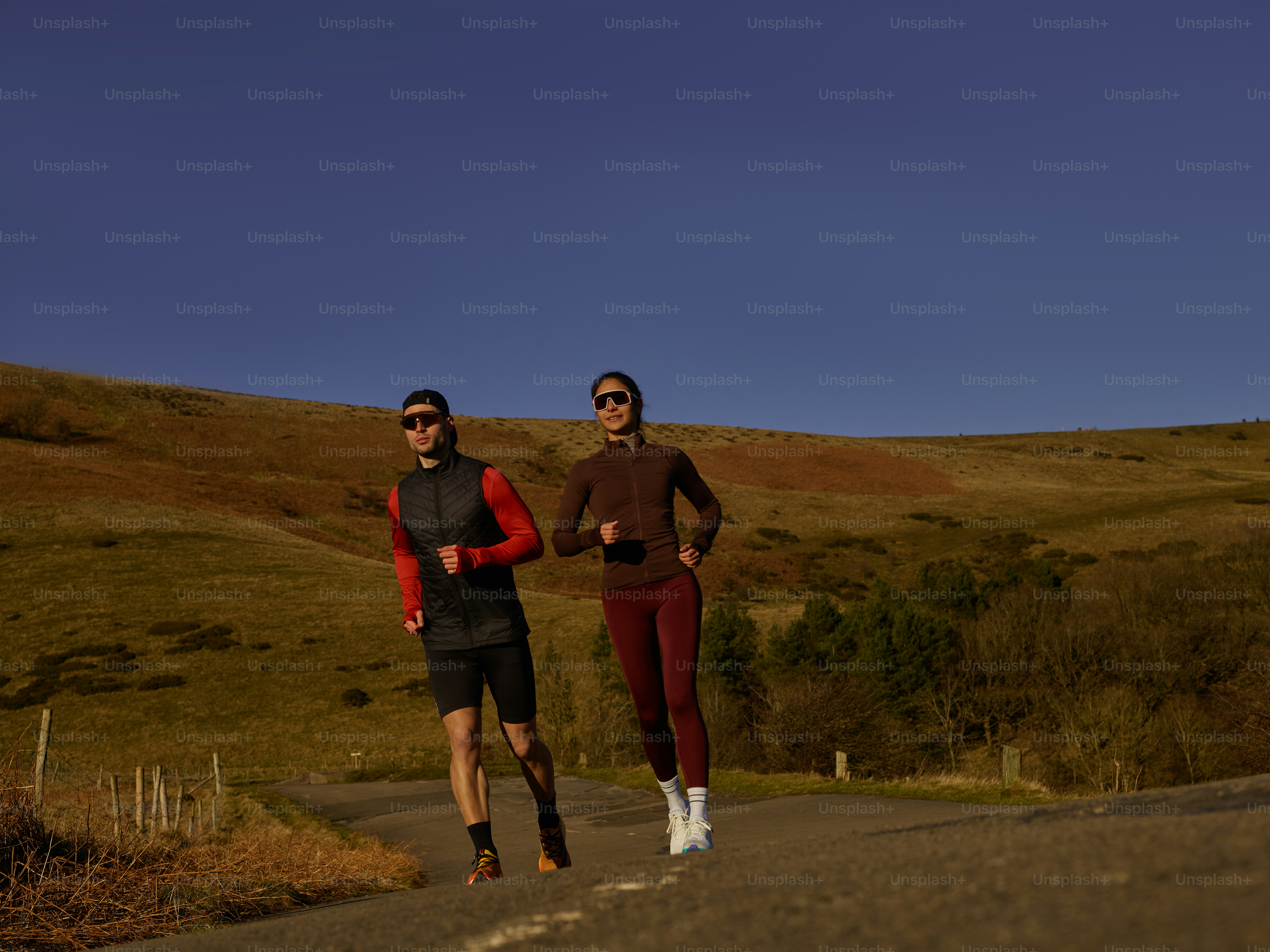 A couple of people that are running down a road photo – Training Image ...