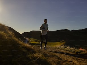 a man running on a trail in the mountains