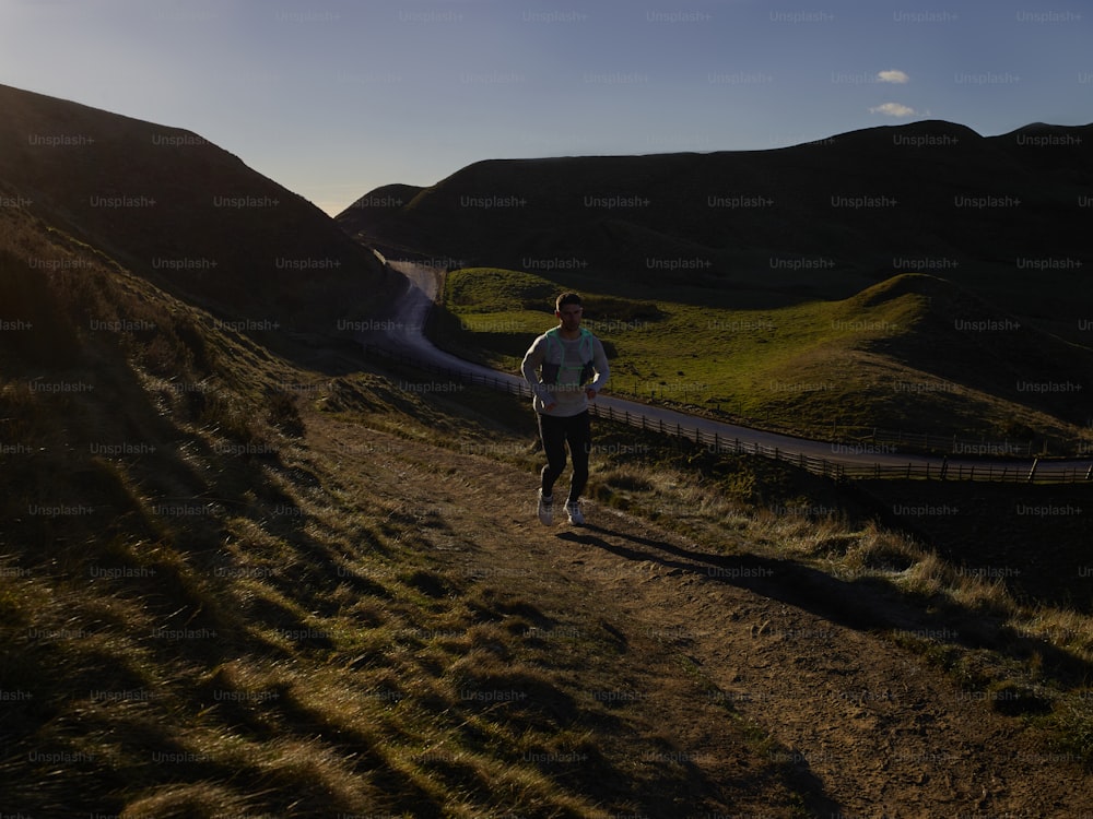 a man running on a path in the mountains