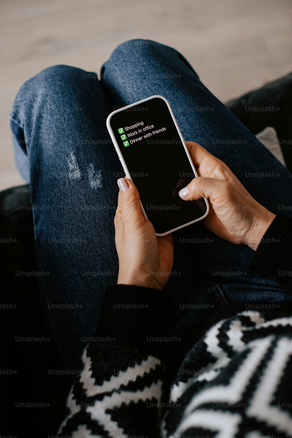 a person sitting on a couch holding a cell phone