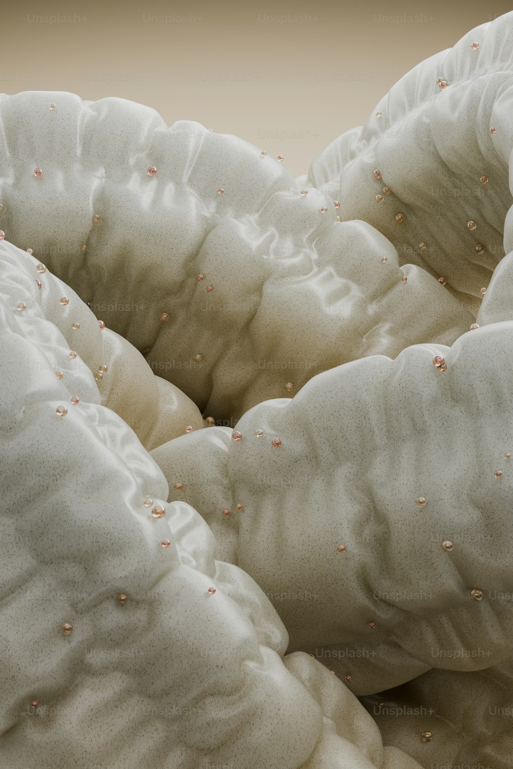 a pile of white pillows with tiny pink dots on them