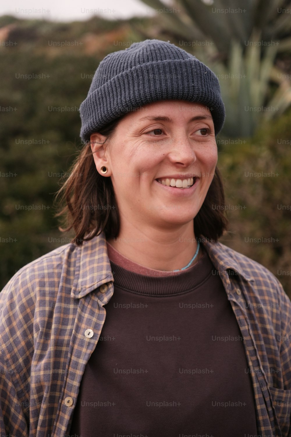 a woman wearing a hat and smiling for the camera