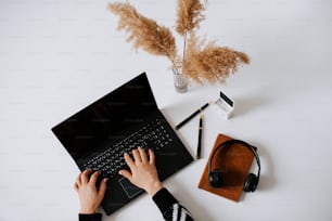 a person typing on a laptop with headphones on