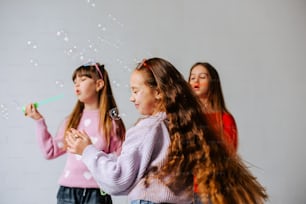 a group of young girls blowing bubbles in the air