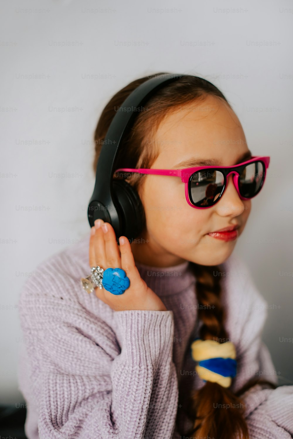 a little girl wearing headphones and sunglasses