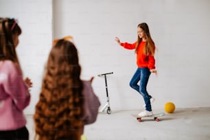 a young girl riding a skateboard next to two other young girls