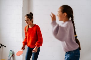 two young girls playing a game of ping pong