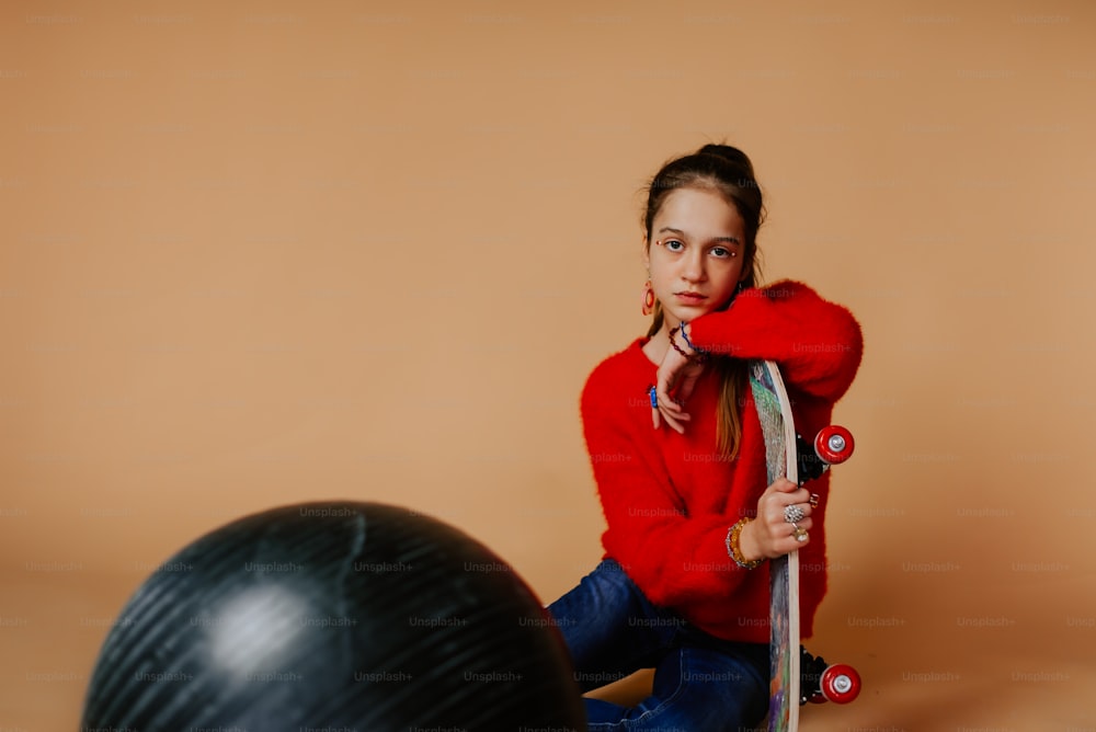 a woman in a red sweater holding a skateboard