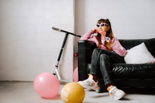 a girl sitting on a couch with a toothbrush in her mouth