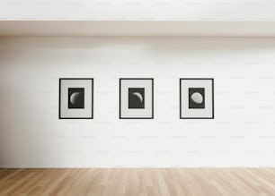 a room with three black and white pictures on the wall
