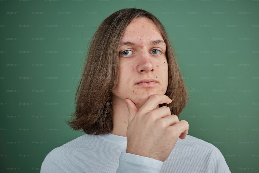 a man with long hair is looking at the camera