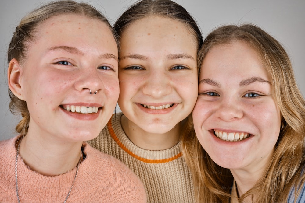a group of three girls standing next to each other