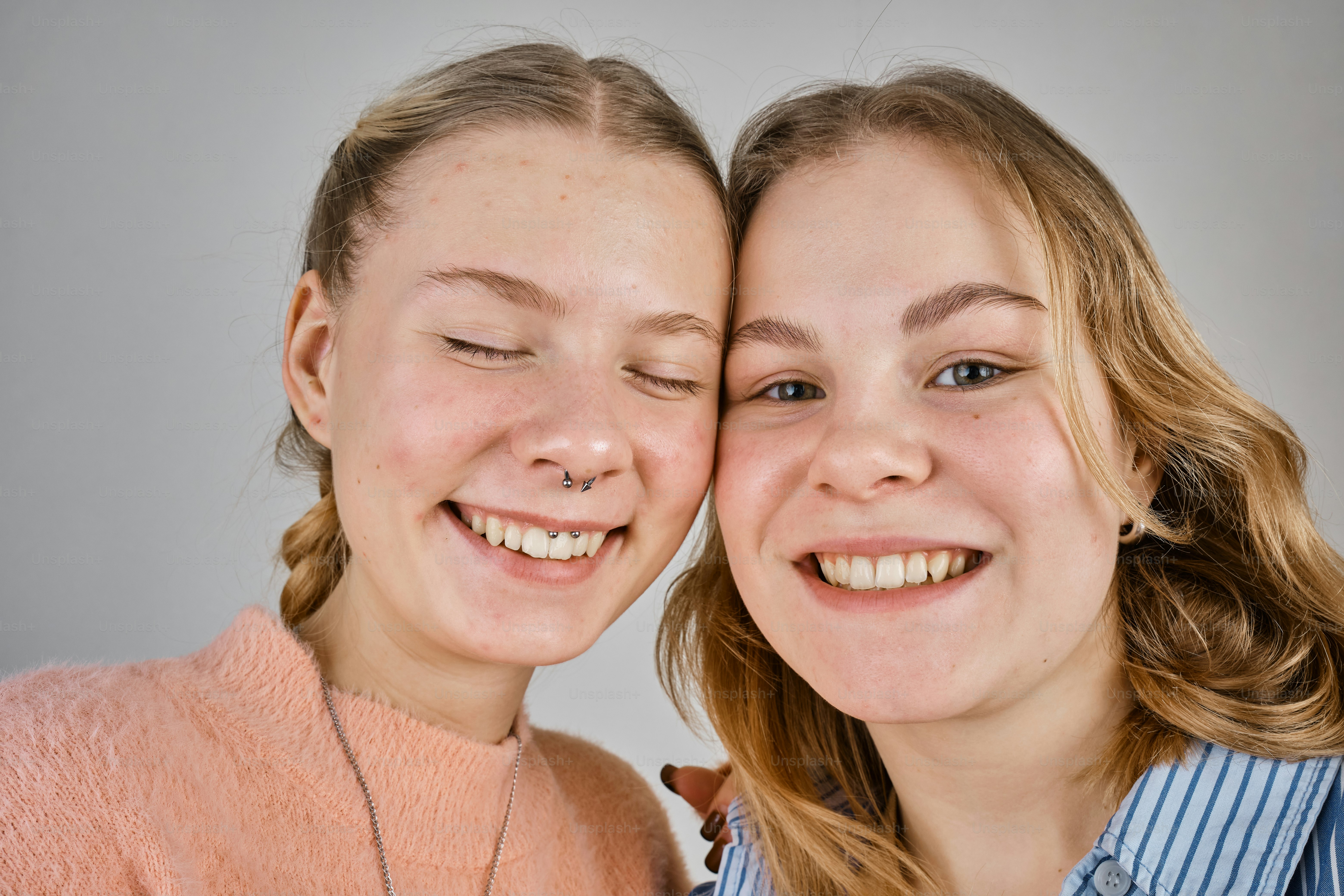 two girls are smiling and posing for a picture