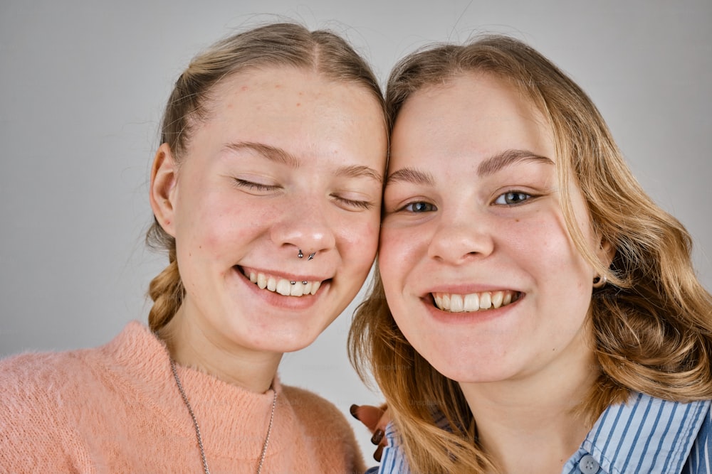 two girls are smiling and posing for a picture