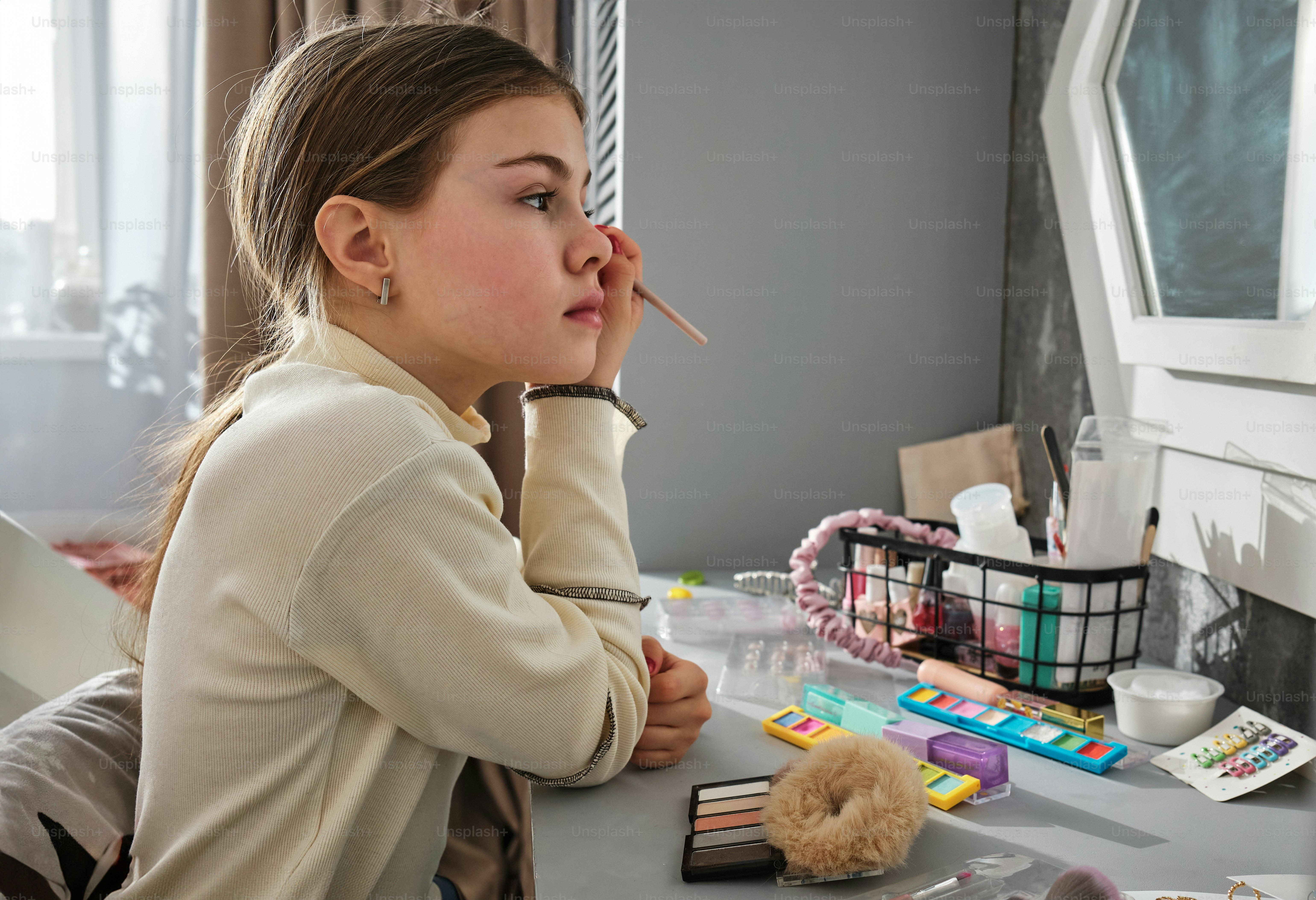 ein Mädchen, das mit einer Zigarette im Mund an einem Schreibtisch sitzt