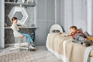 um menino e uma menina sentados em uma cama