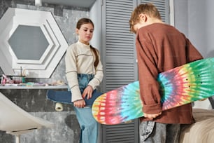 a boy and a girl with skateboards in a room